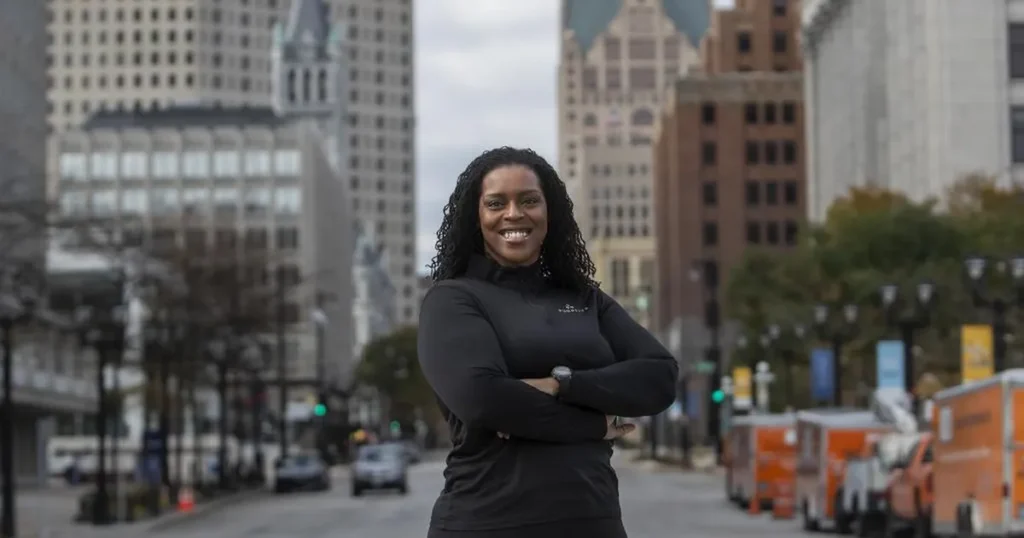 Confident woman stands in city street, smiling