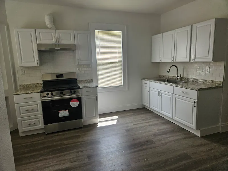 Clean kitchen interior with white cupboards and walls