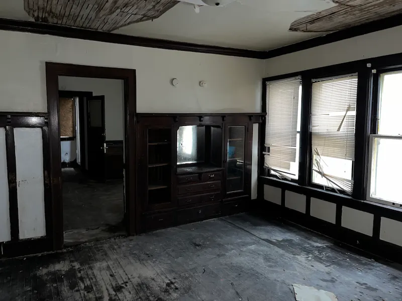 Dark interior room with floor removed. White walls and dark wood trim