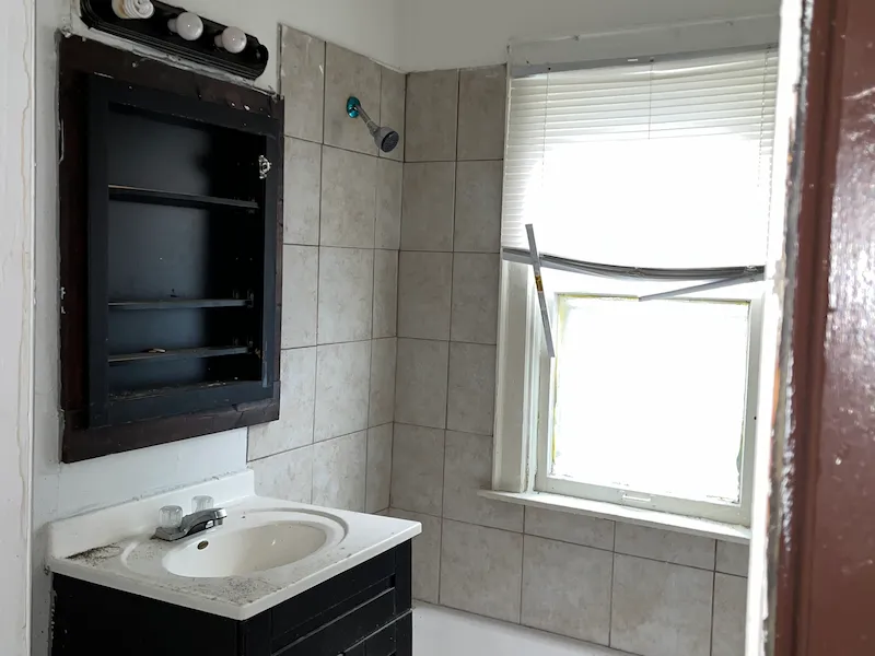 Old bathroom with gray tile and black vanity