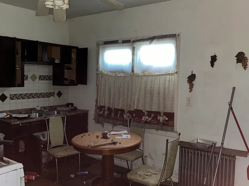 Old kitchen with dark cabinets and chipping walls