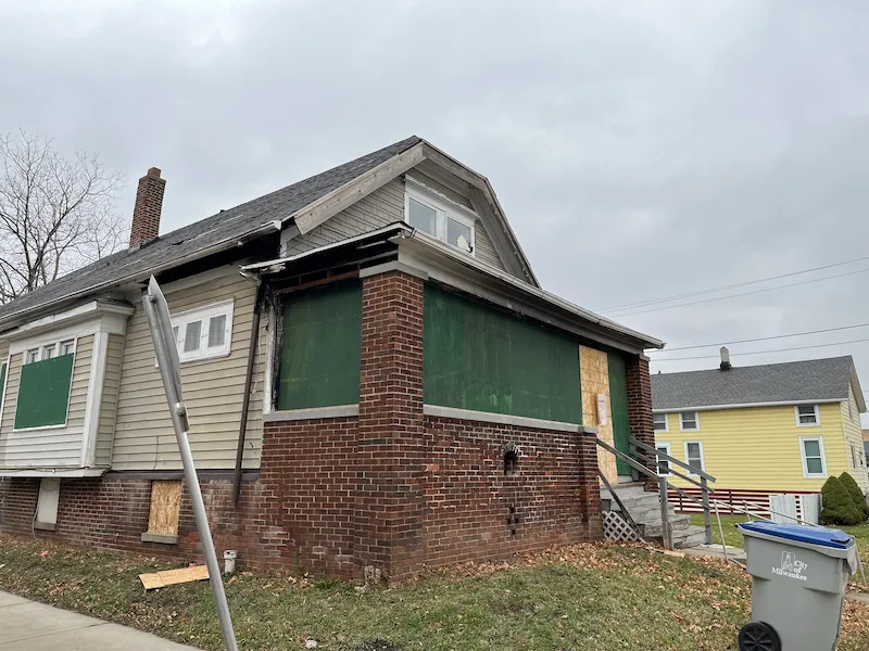 Old boarded up house with brick porch