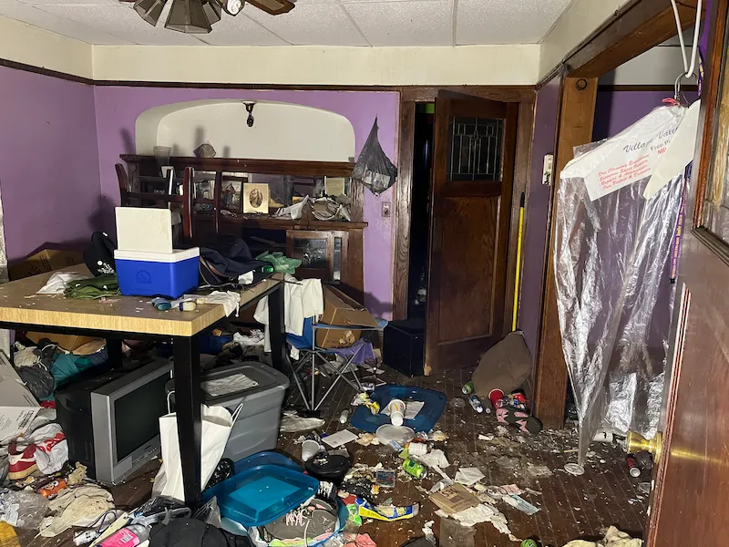 Old interior room with purple walls, filled with trash