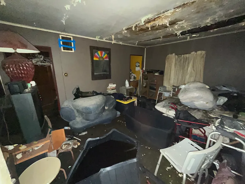 Dark interior room with gray walls full of garbage